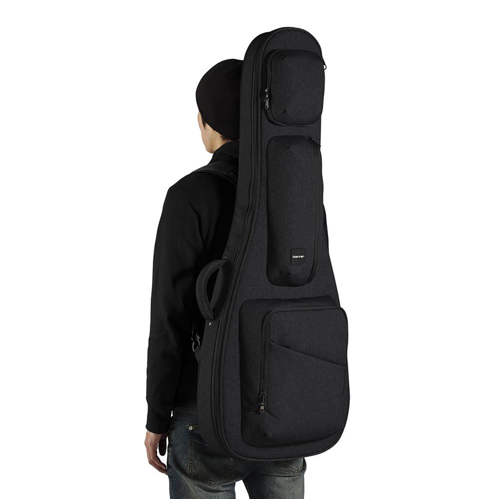 The man backpacks the black ACME acoustic guitar bag